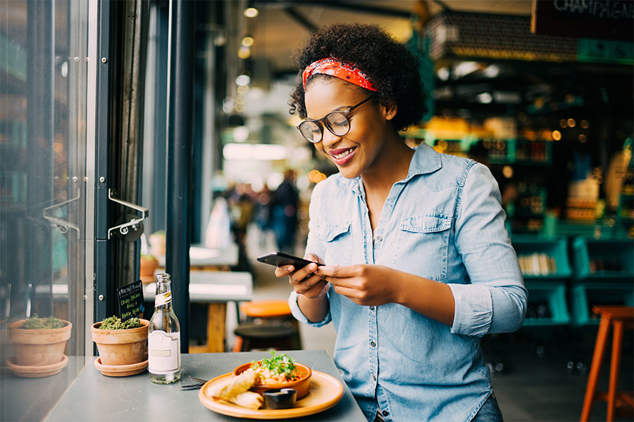 female in restaurant checking phone messages