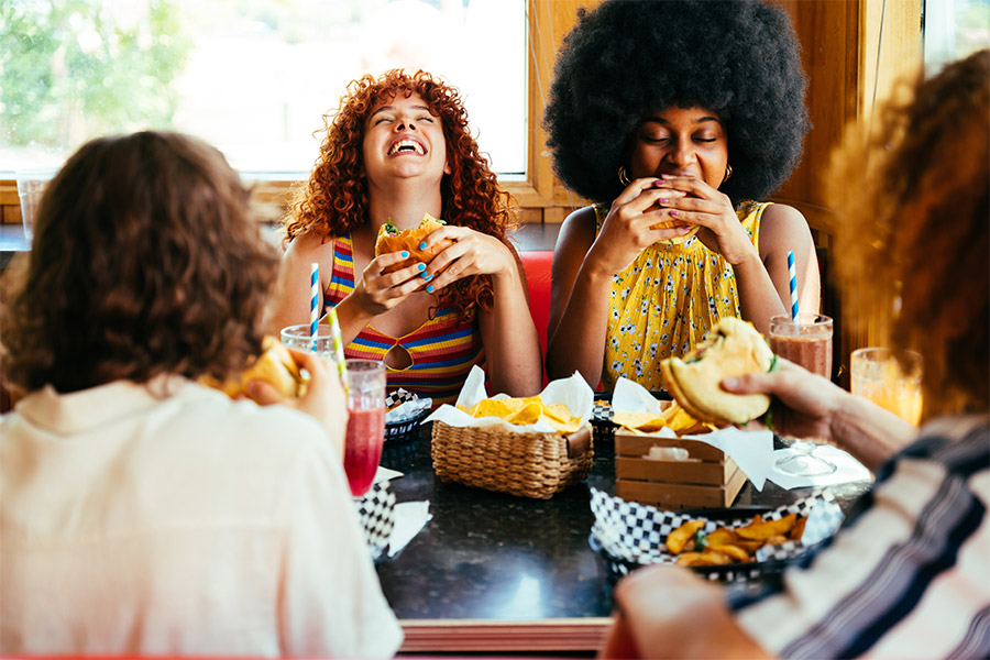 Group of friends filling seats at burger restaurant